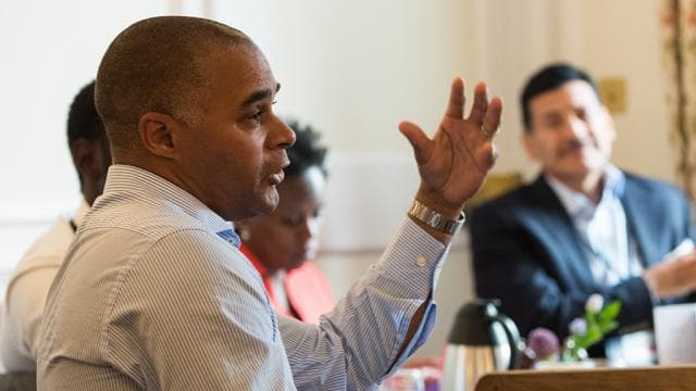A participant gestures while speaking during a group discussion