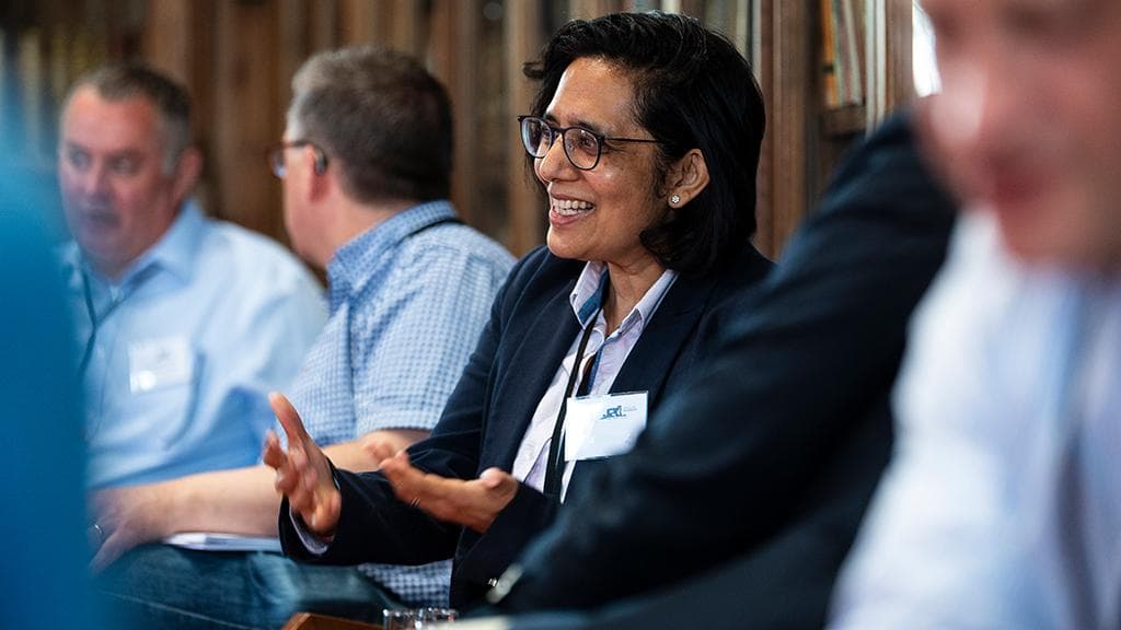 A smiling alumna speaks during a group discussion