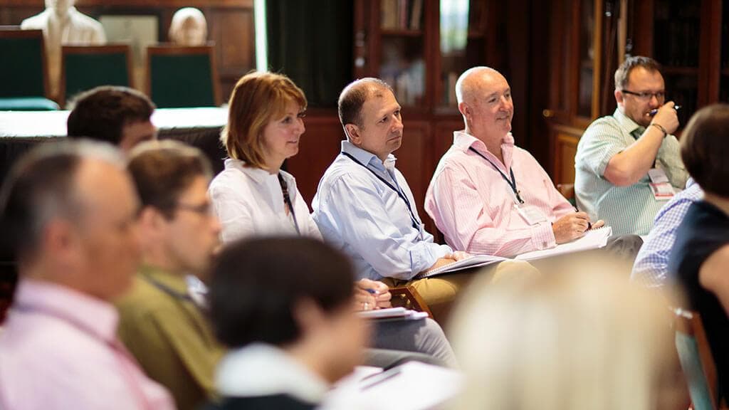 Participants seated in a group session, listening to a speaker
